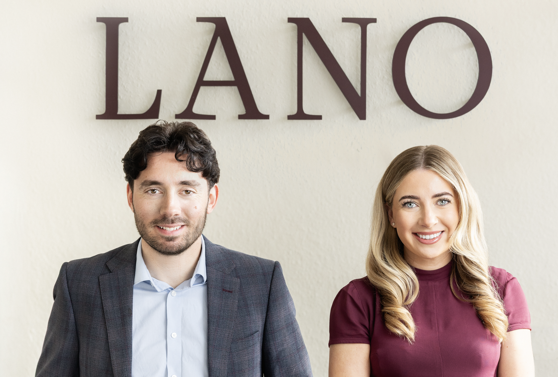 Stephanie and Paul, founders of Lano Properties, beneath the Lano sign